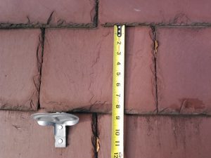 Measuring a slate roof tile to find the exposure to determine the length of slate.