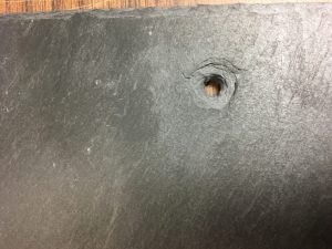 Countersink nail hole on face of the slate