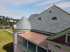 Roof details of a slate turret and copper eyebrow dormers